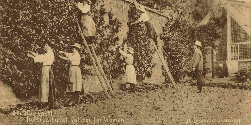 Sepia photograph of women gardeners training wall plants