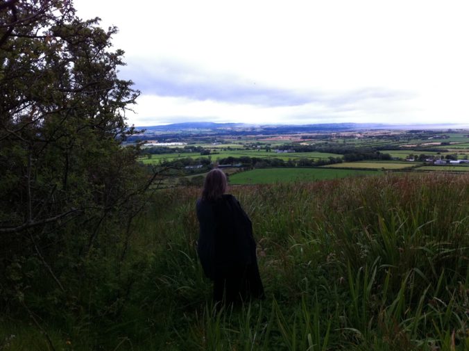 A figure looking to the distant horizon, from a hilltop in Northern Ireland