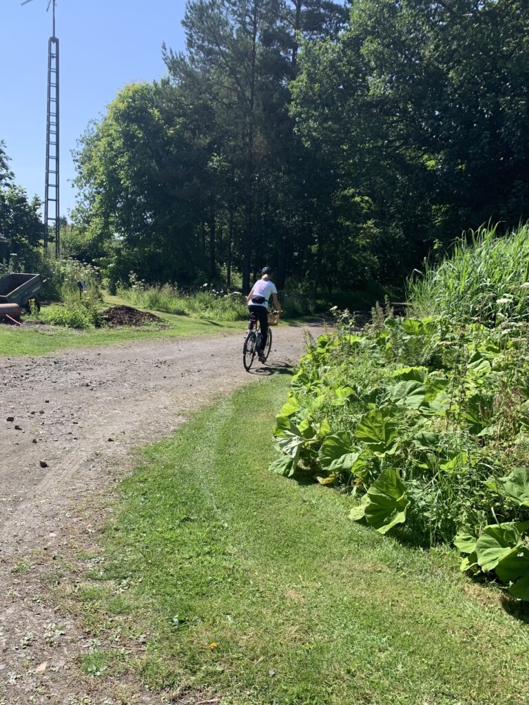 A picture of Debs Reid leaving Pond Cottage on her bike